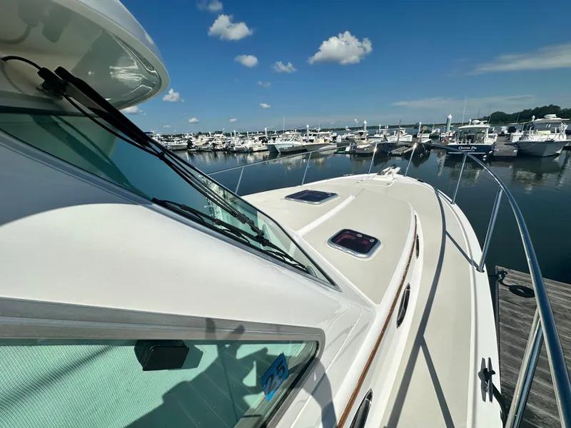 Slide: The Image of 2013 Back Cove 34 yacht docked at a marina under a clear blue sky. - 15