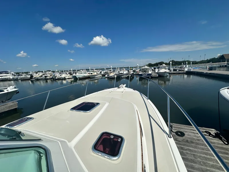 Slide: The Image of 2013 Back Cove 34 boat docked at a marina under a clear blue sky. - 16