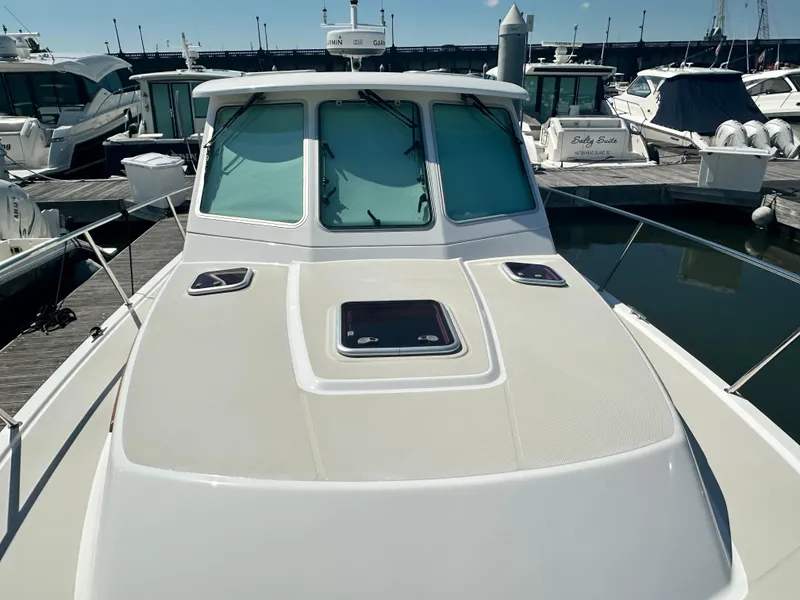 Slide: The Image of 2013 Back Cove 34 boat docked at marina, showcasing sleek design and spacious deck. - 22