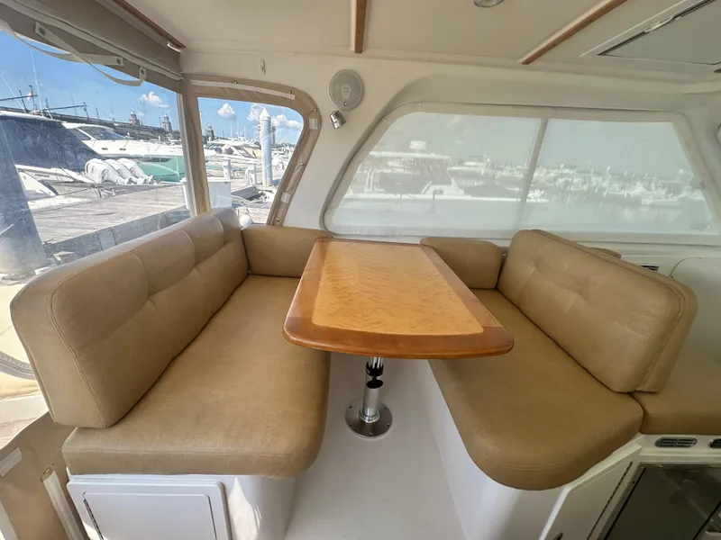 Slide: The Image of Interior of 2013 Back Cove 34 boat with beige seating and wooden table. - 34
