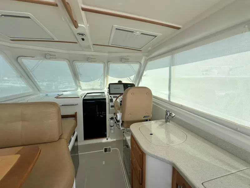 Slide: The Image of Interior of a 2013 Back Cove 34 boat, featuring helm and seating area. - 36