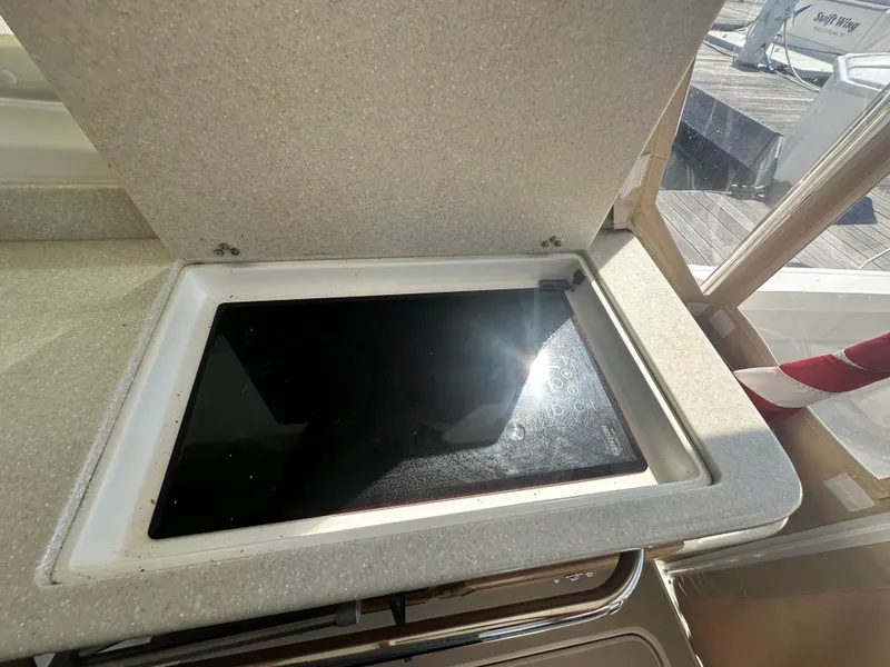 Slide: The Image of 2013 Back Cove 34 yacht interior with open stove cover, sunlight reflecting on surface. - 38