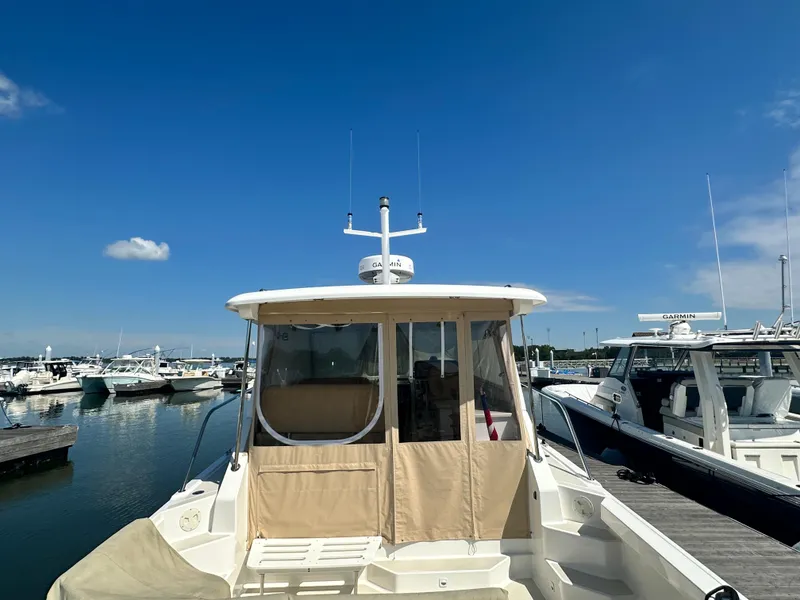 Slide: The Image of 2013 Back Cove 34 boat docked at marina under clear blue sky. - 4