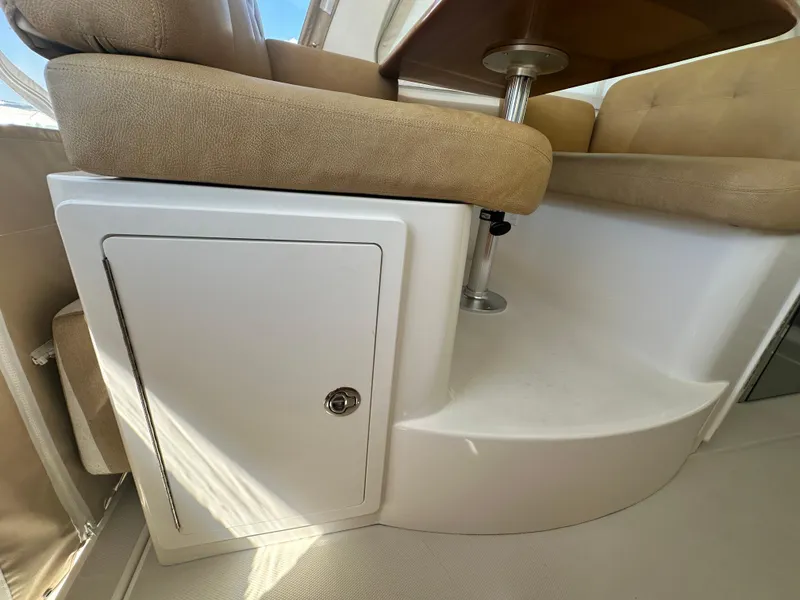 Slide: The Image of 2013 Back Cove 34 interior seating with storage compartment and table. - 49