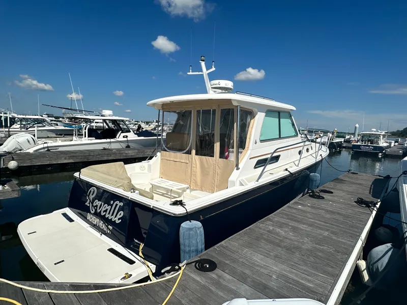Slide: The Image of 2013 Back Cove 34 boat docked at marina under clear blue sky. - 6