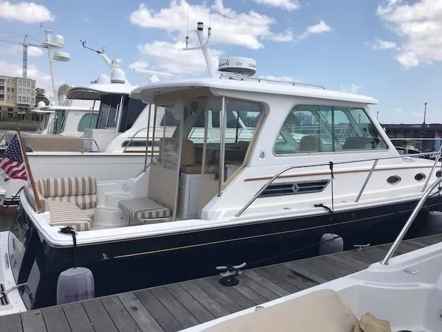 Slide: The Image of 2013 Back Cove 34 yacht docked, featuring a sleek design and spacious seating area. - 7