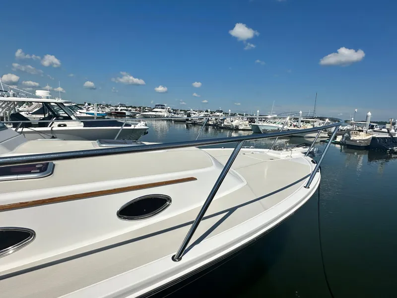 Slide: The Image of 2013 Back Cove 34 yacht docked in a marina under a clear blue sky. - 9