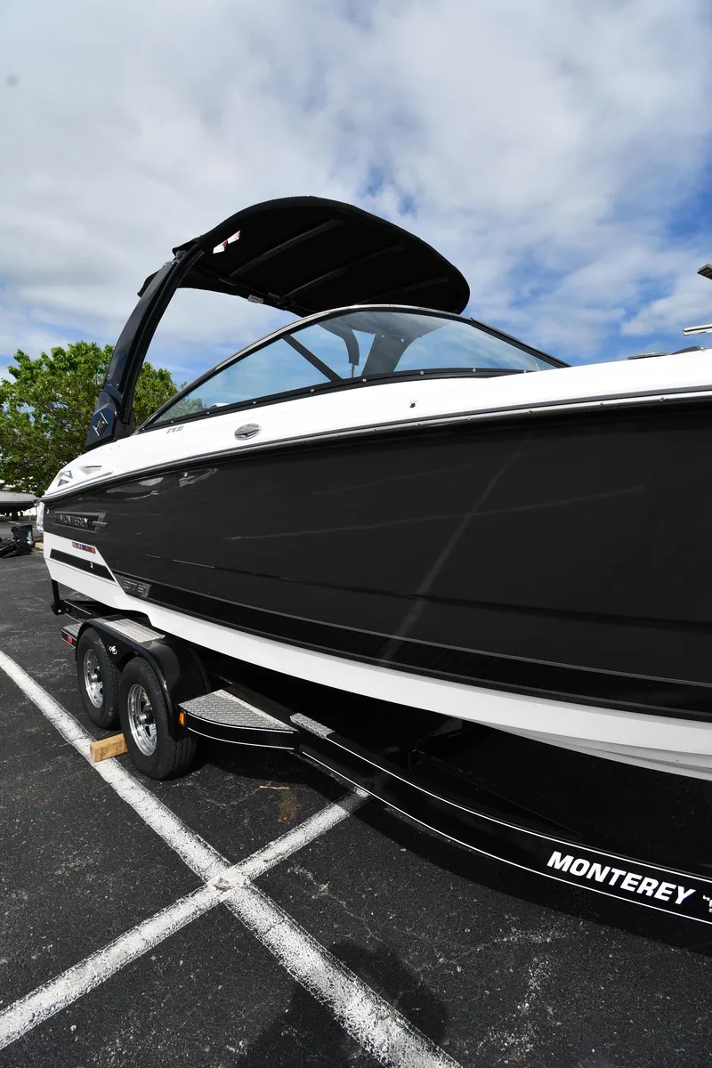 Slide: The Image of 2023 Monterey 278 Super Sport boat on trailer, black and white design, parked outdoors. - 1