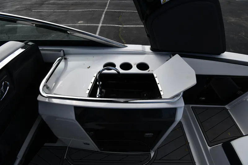 Slide: The Image of 2023 Monterey 278 Super Sport boat interior with open storage compartment and cup holders. - 31