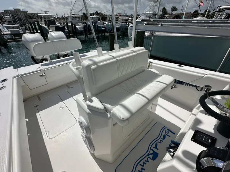Slide: The Image of 2006 Island Runner 35 boat interior with white seating and helm, docked at marina. - 15