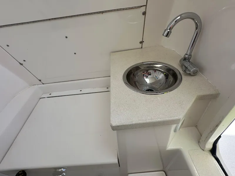Slide: The Image of Compact sink area on a 2006 Island Runner 35 boat, featuring a sleek faucet design. - 34