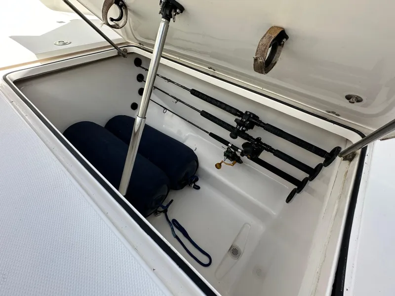 Slide: The Image of Open storage compartment on 2006 Island Runner 35 boat with fishing rods and fenders. - 42