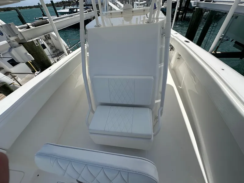 Slide: The Image of 2006 Island Runner 35 boat interior with white seating and console, docked at marina. - 49
