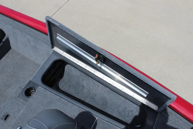 Slide: The Image of 2025 Tracker Pro Team 175 boat storage compartment with open lid and measuring ruler. - 15