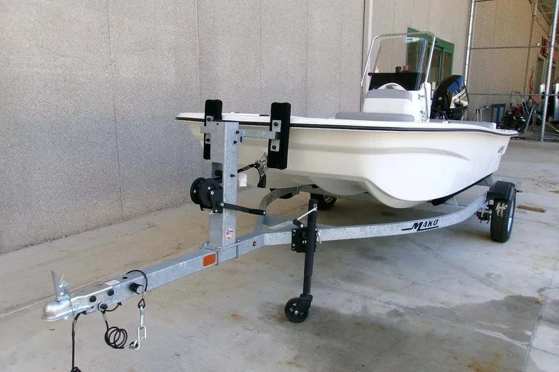 Slide: The Image of 2025 Mako Pro Skiff 13 CC boat on trailer, parked indoors. - 2