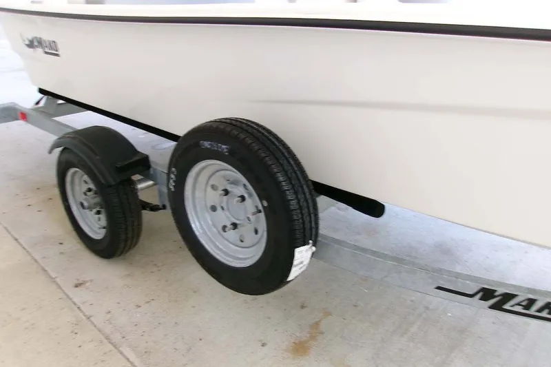 Slide: The Image of 2025 Mako Pro Skiff 13 CC on trailer, showcasing wheels and hull detail. - 3