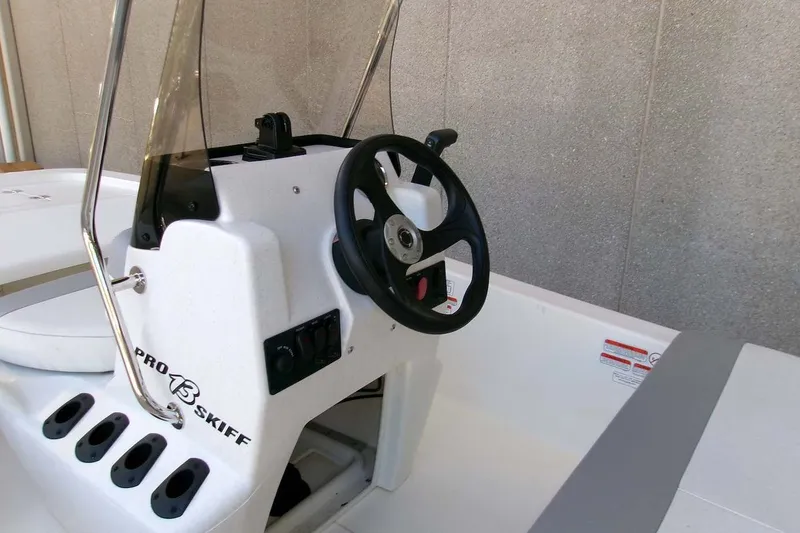 Slide: The Image of 2025 Mako Pro Skiff 13 CC boat console with steering wheel and controls. - 4