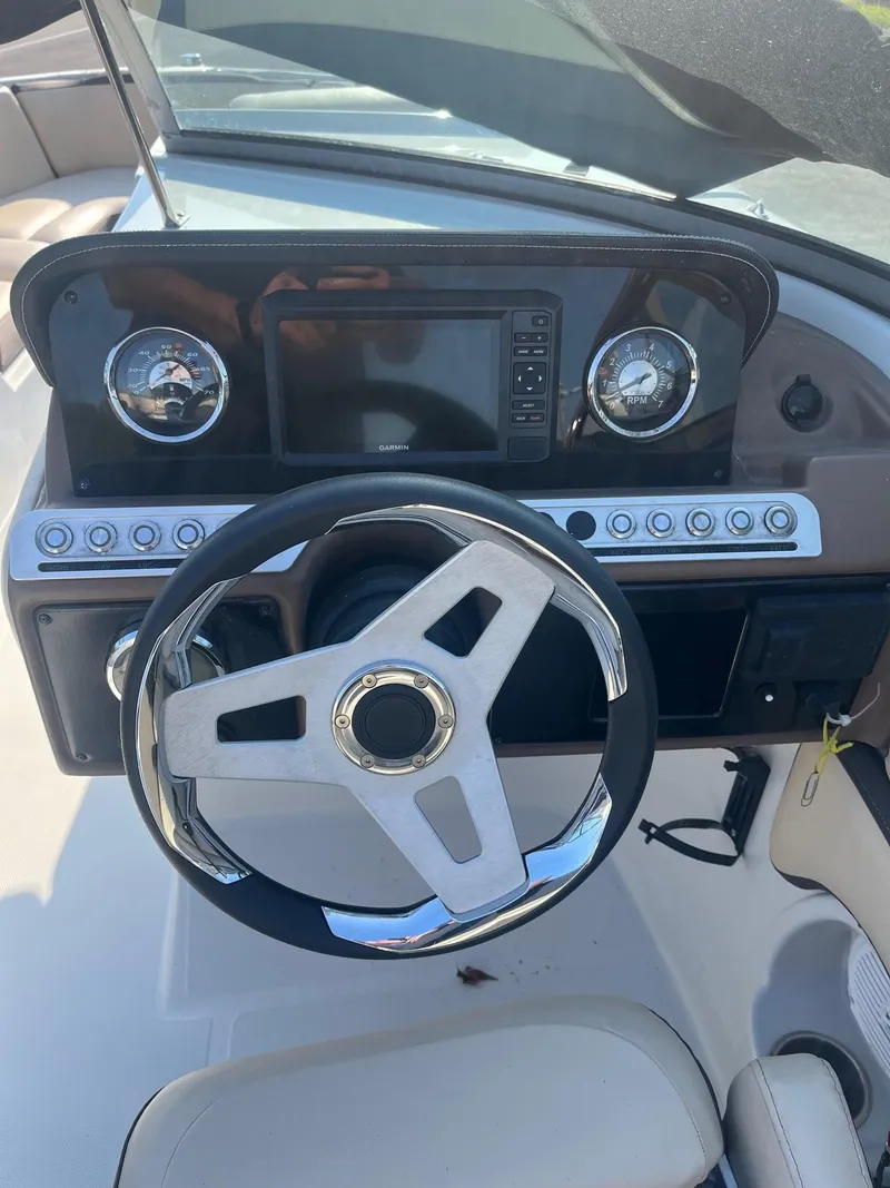 Slide: The Image of 2022 Crownline 260 XSS boat dashboard with steering wheel and controls. - 8