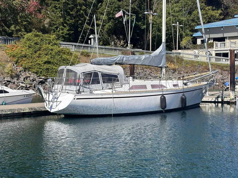 Slide: The Image of 1985 Whiting 40 sailboat docked in a serene marina setting. - 0