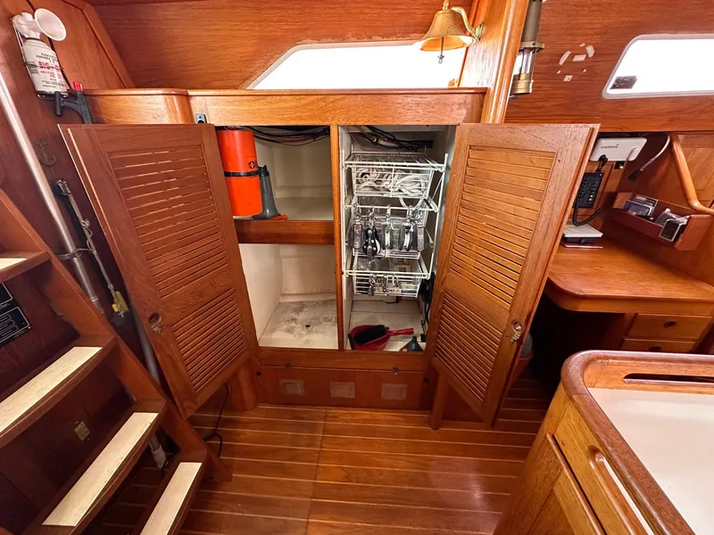 Slide: The Image of Interior of 1985 Whiting 40 sailboat with wooden cabinetry and storage compartments. - 13