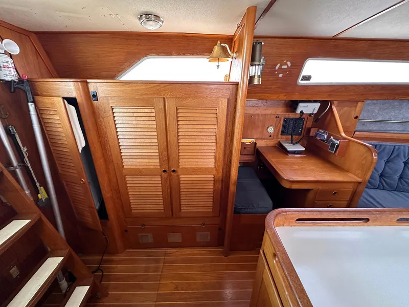 Slide: The Image of Interior of 1985 Whiting 40 sailboat with wooden cabinetry and navigation station. - 14