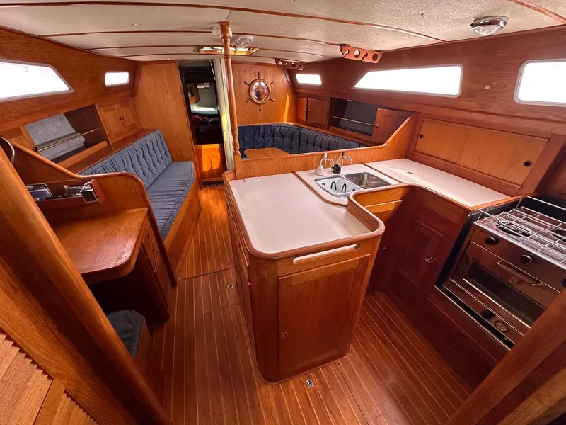 Slide: The Image of Interior of 1985 Whiting 40 sailboat with wood finish and compact kitchen area. - 15