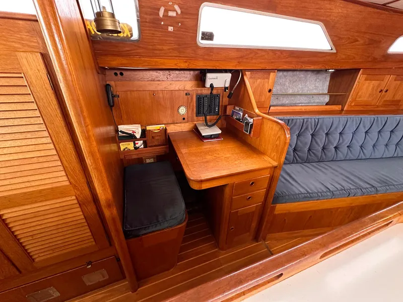 Slide: The Image of 1985 Whiting 40 sailboat interior with wooden desk and seating area. - 16