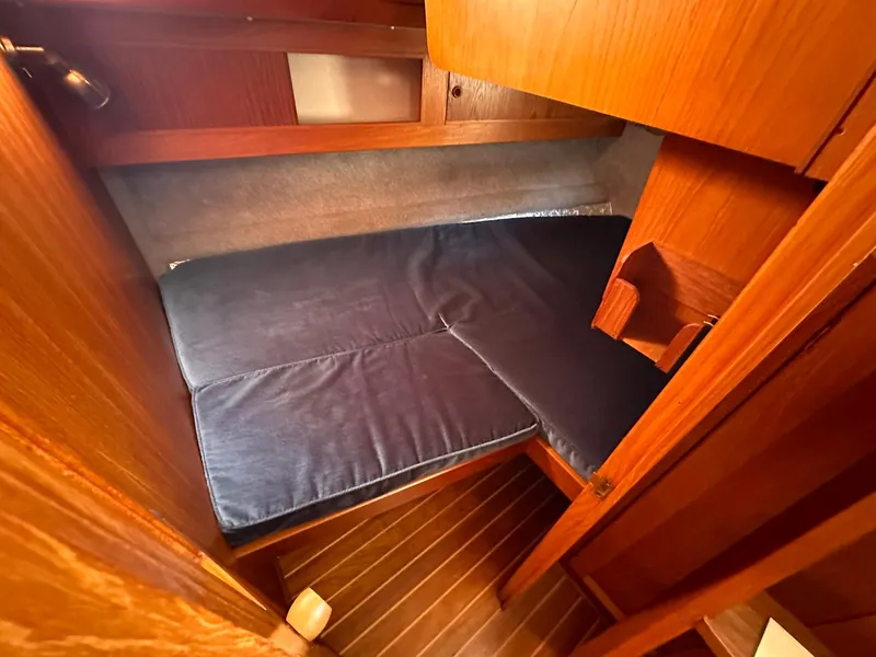 Slide: The Image of Cozy cabin interior of 1985 Whiting 40 sailboat with wooden finish and blue mattress. - 23