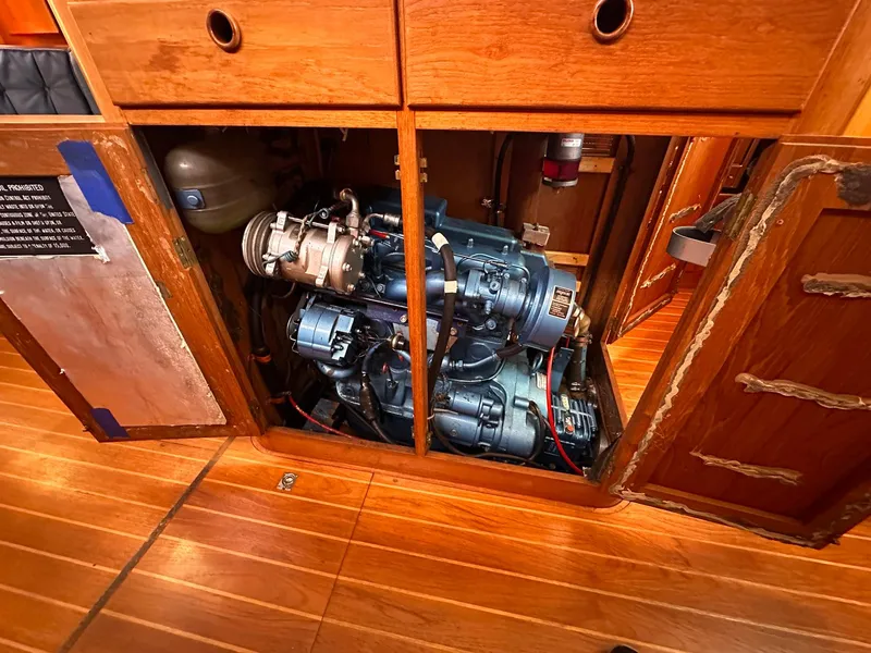 Slide: The Image of Engine compartment of a 1985 Whiting 40 sailboat, featuring a well-maintained marine engine. - 24
