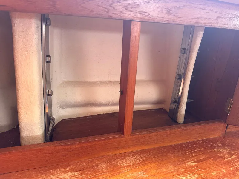 Slide: The Image of Interior view of a 1985 Whiting 40 sailboat, showcasing wooden cabinetry and structural elements. - 25