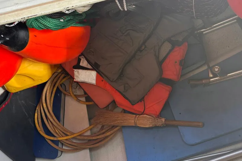 Slide: The Image of Storage compartment with life jackets, buoys, rope, and a broom on a Whiting 40 sailboat. - 26
