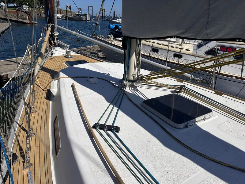 Slide: The Image of 1985 Whiting 40 sailboat deck with rigging, docked at a marina. - 3