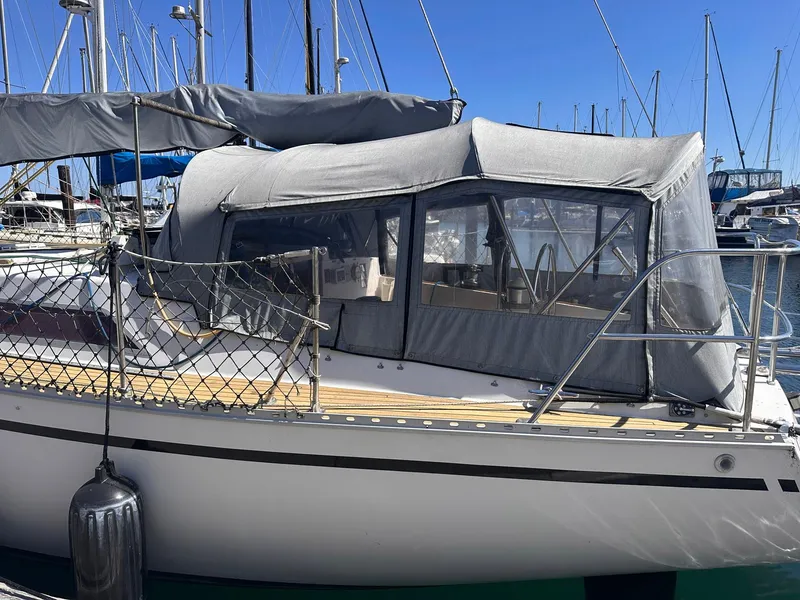 Slide: The Image of 1985 Whiting 40 sailboat with gray canopy docked in marina. - 5