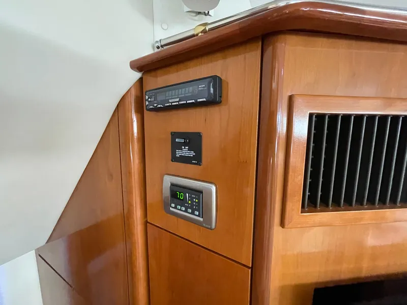 Slide: The Image of 2006 Carver 466 Motor Yacht interior with control panel and wooden cabinetry. - 14