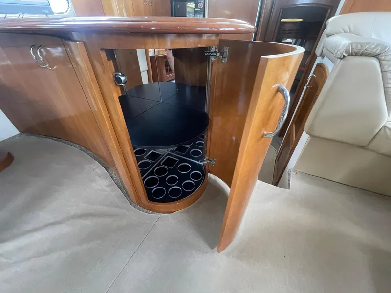 Slide: The Image of 2006 Carver 46 Motor Yacht interior with open wooden cabinet and circular storage. - 19