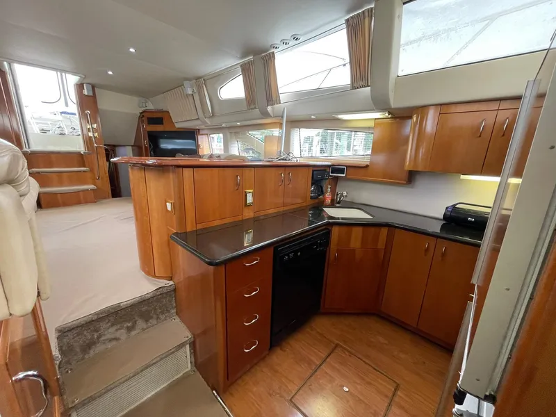 Slide: The Image of Luxurious interior of 2006 Carver 466 Motor Yacht with modern kitchen and wood cabinetry. - 23