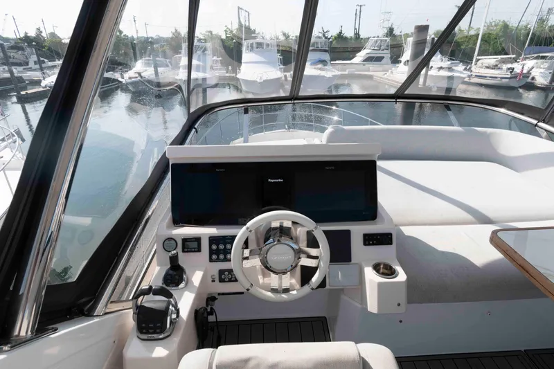 Slide: The Image of 2022 Azimut Fly 50 yacht helm with modern navigation equipment and marina view. - 13