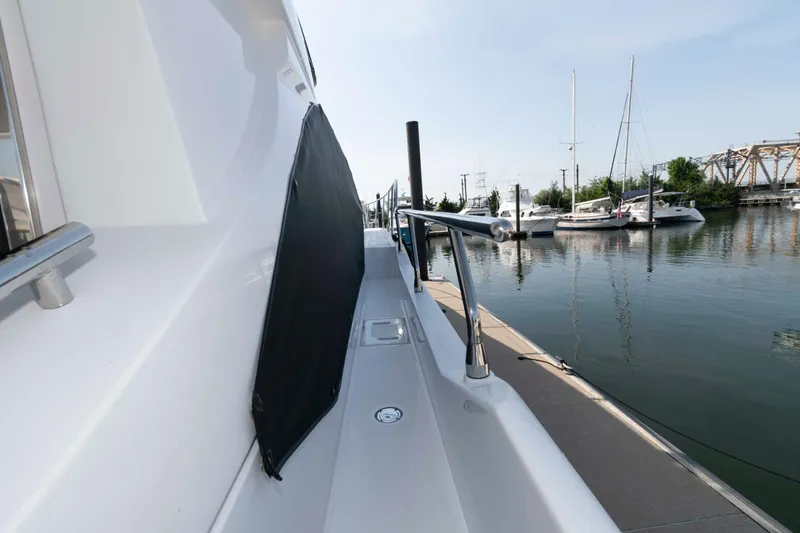 Slide: The Image of 2022 Azimut Fly 50 yacht docked at marina, side view with railing and water reflection. - 20
