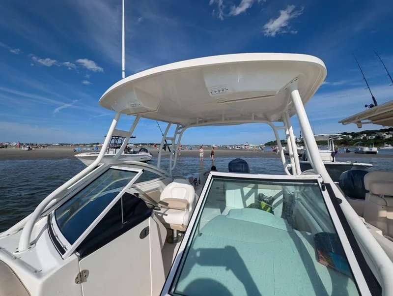 Slide: The Image of 2018 Robalo R247 Dual Console boat on water under clear blue sky. - 4