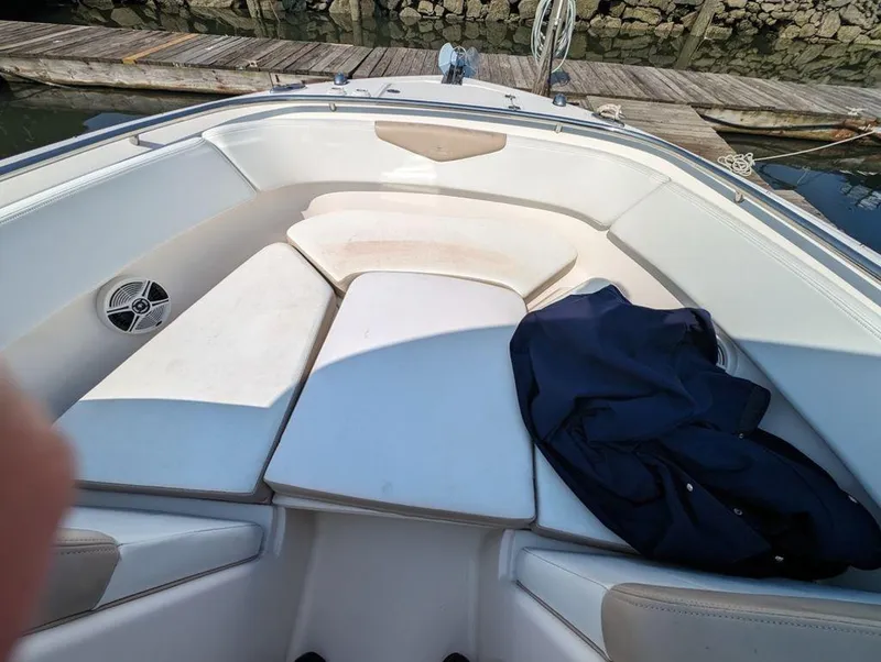 Slide: The Image of 2018 Robalo R247 Dual Console boat interior with cushioned seating and dock view. - 6