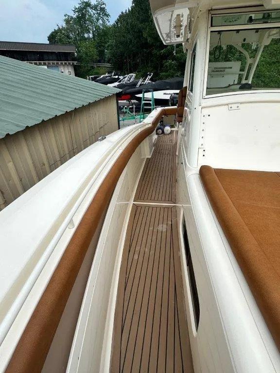 Slide: The Image of 2018 Scout 350 LXF boat deck with brown seating and white exterior. - 13