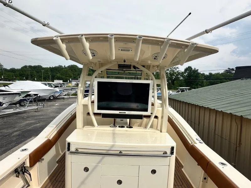 Slide: The Image of 2018 Scout 350 LXF boat with center console and mounted screen, docked outdoors. - 15