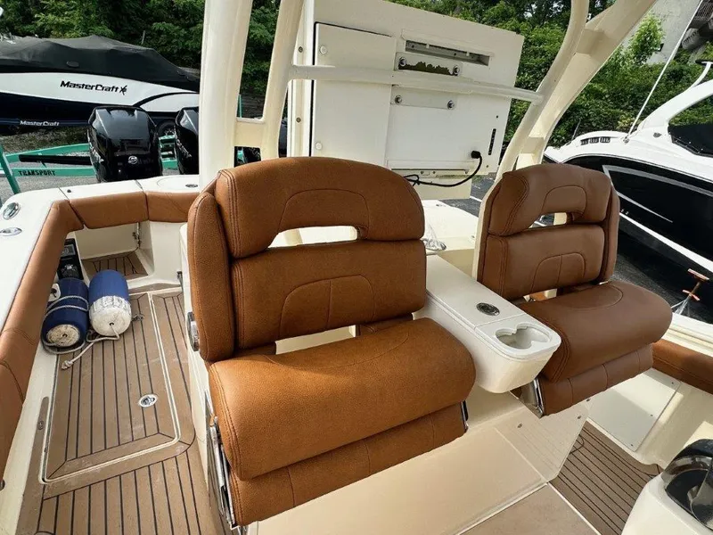 Slide: The Image of 2018 Scout 350 LXF boat interior with brown seating and teak flooring. - 16