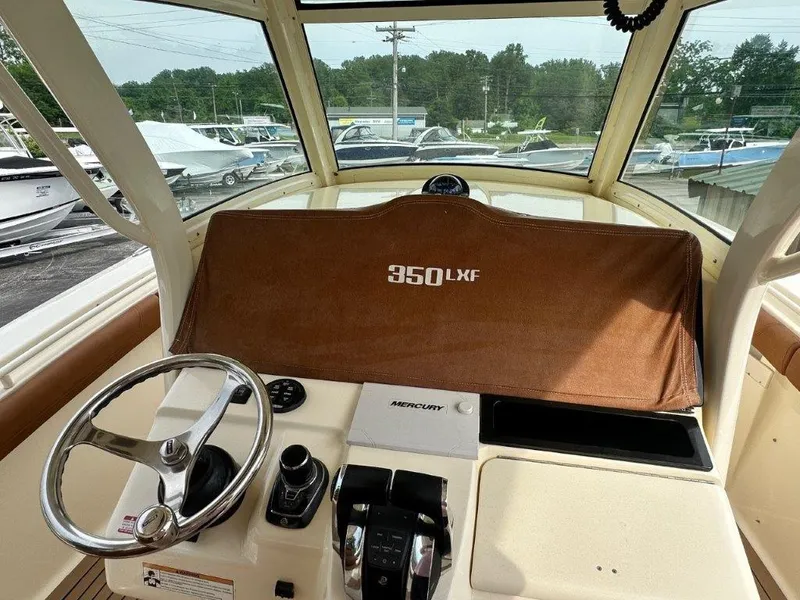 Slide: The Image of 2018 Scout 350 LXF boat dashboard with steering wheel and Mercury controls. - 17