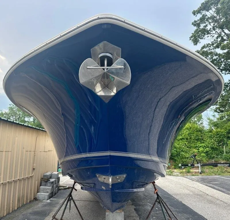 Slide: The Image of 2018 Scout 350 LXF boat, blue hull, front view, on stands, outdoors. - 2