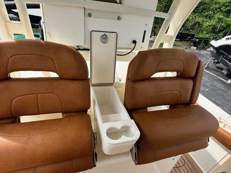 Slide: The Image of 2018 Scout 350 LXF boat seats with brown upholstery and central cup holders. - 20