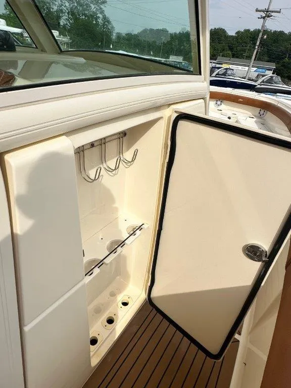 Slide: The Image of 2018 Scout 350 LXF boat storage compartment with open door and hooks. - 23
