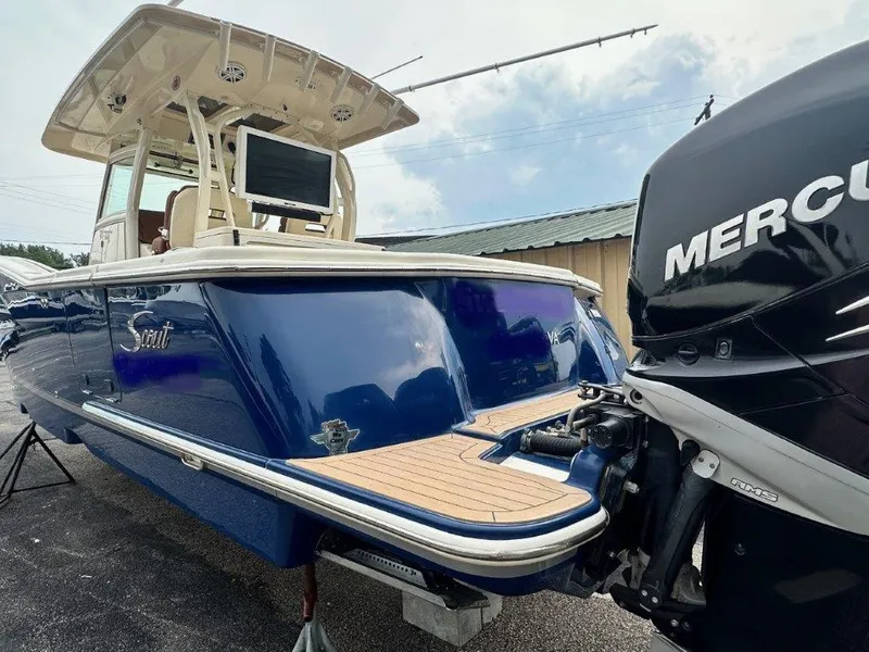 Slide: The Image of 2018 Scout 350 LXF boat with Mercury engine, blue hull, and spacious deck. - 26