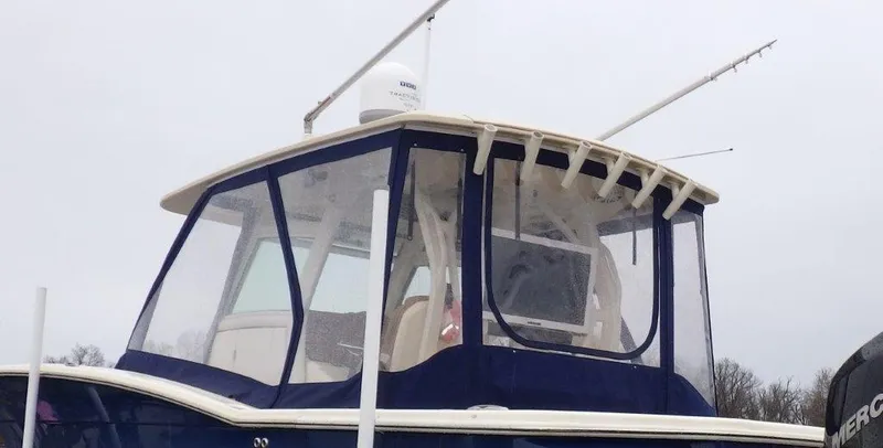 Slide: The Image of 2018 Scout 350 LXF boat with enclosed helm and fishing rods. - 29