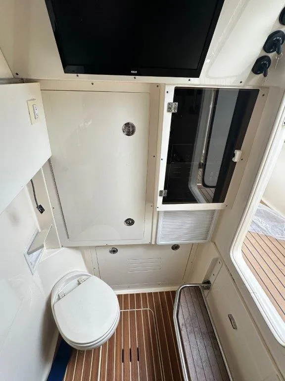 Slide: The Image of 2018 Scout 350 LXF boat interior with wooden flooring and compact bathroom. - 8